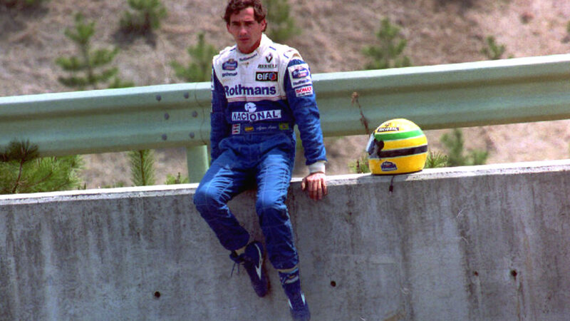 Ayrton Senna sits on on a trackside wall after being pushed out of the 1994 Pacific Grand Prix